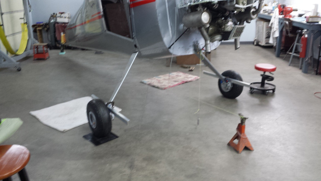 A 3' length of alum angle is lightly clamped to each brake rotor. and the string tied to the jackstand touches plumb bobs dropped at the front and rear. Toe is measured to the string. Camber is measured with a race car bubble camber gauge.